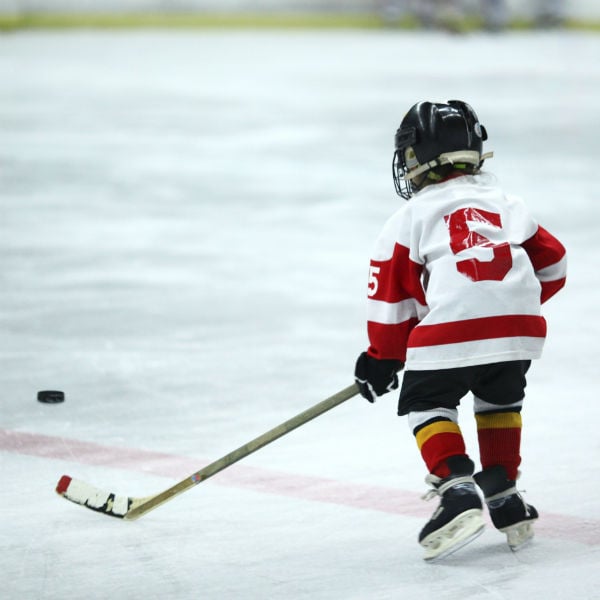 Little kid in hockey jersey skating on the ice