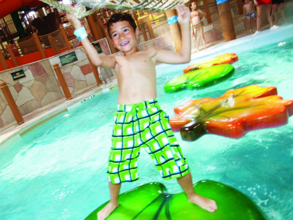 boy playing on a water jungle gym