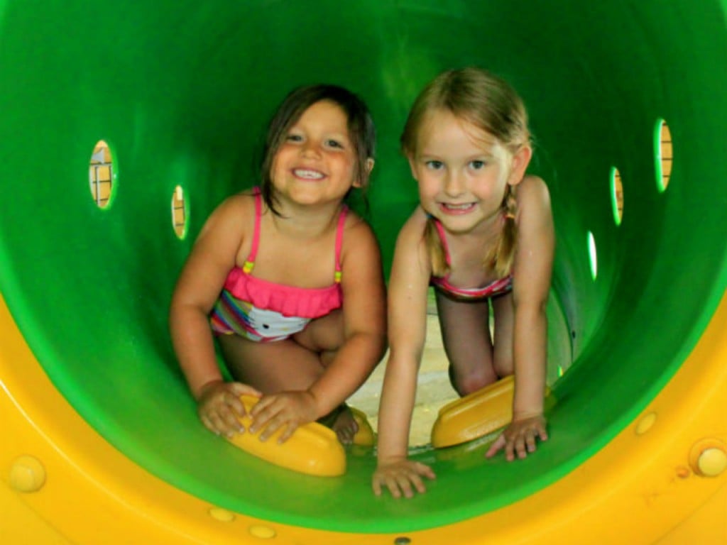 two girl in a playground tunnel