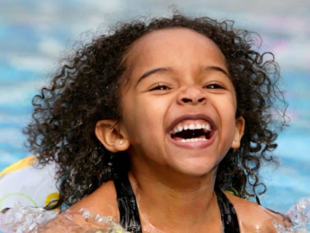 little girl smiling in the pool