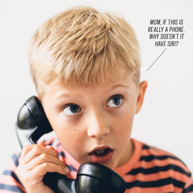 school-aged boy talking on the phone with a surprised look on his face