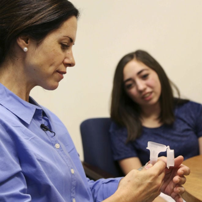 Erin Lopes gives a saliva sample for the Autism Sisters Project, which is building a database to help scientists look for genetic clues and protective factors. Her son, Tommy, was diagnosed with autism at age 3. Her daughter, Evee does not have the condition. Photo: Erin Lopes gives a saliva sample for the Autism Sisters Project, which is building a database to help scientists look for genetic clues and protective factors. Her son, Tommy, was diagnosed with autism at age 3. Her daughter, Evee does not have the condition. Photo: AP Photo/Seth Wenig