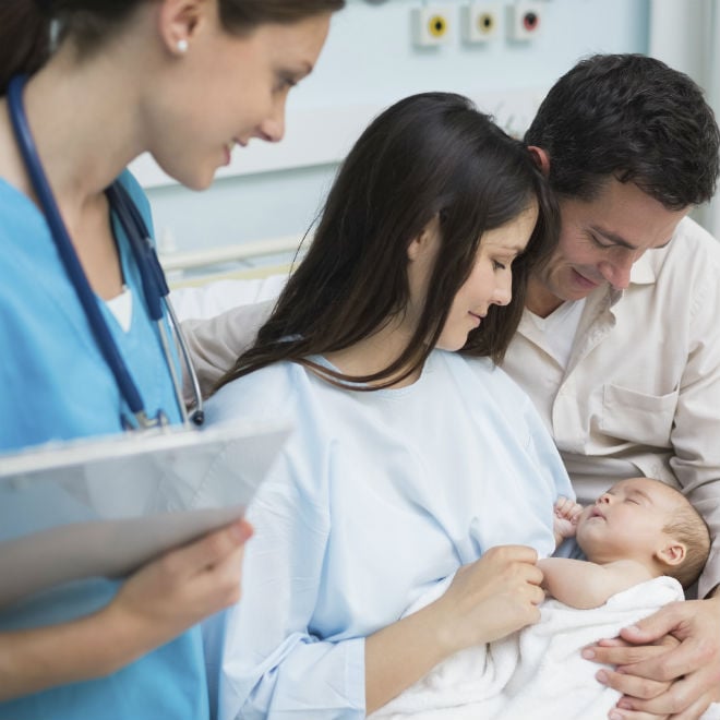 paediatrician with couple holding newborn