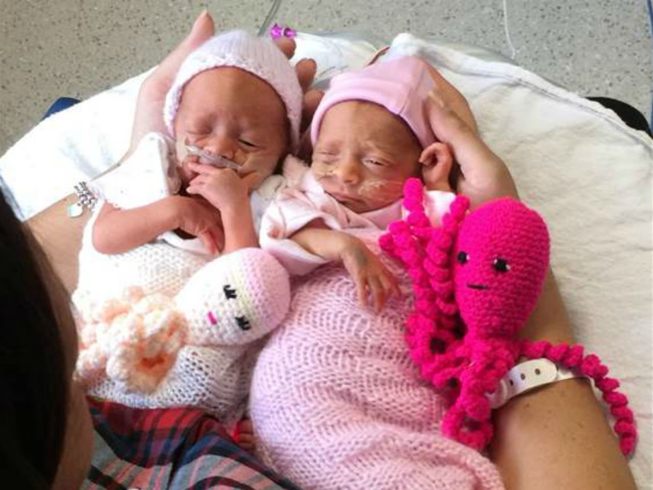 Twin preemies snuggling with crochet octopuses
