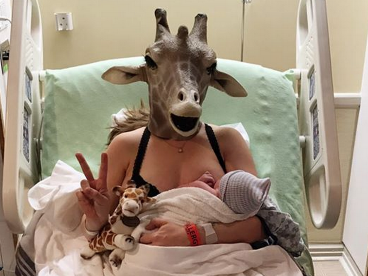 woman with baby wearing giraffe mask