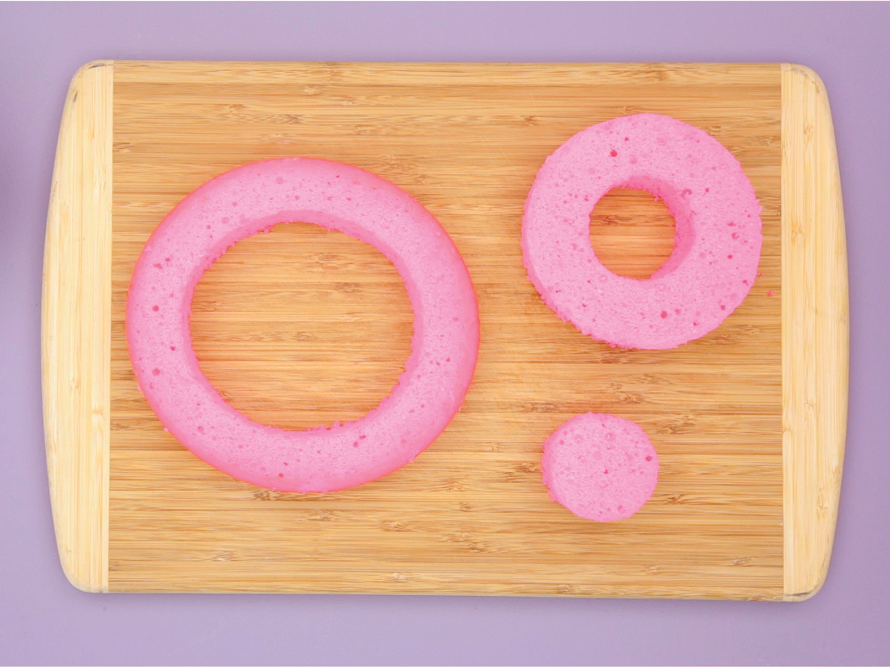 cutting board with pink cake on it