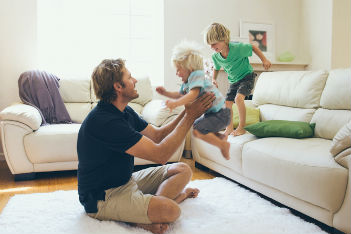 Dad playing with kids on the couch
