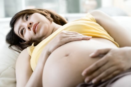 pregnant woman holds hands on belly