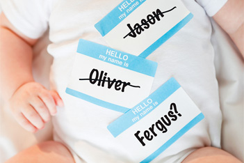 baby with name stickers crossed out