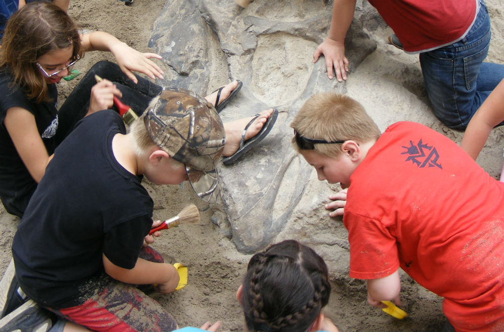 kids digging up dinosaur fossils