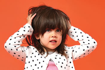 little girl with super lice scratching her head