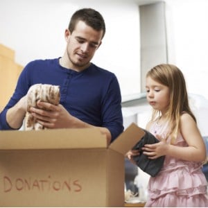 dad and daughter packing a box for charity donations