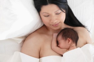 Mother holding her newborn baby skin to skin