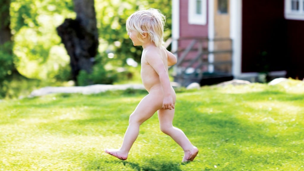 naked toddler running through grass