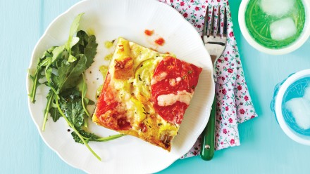 plate of egg strata with tomato and salad on side