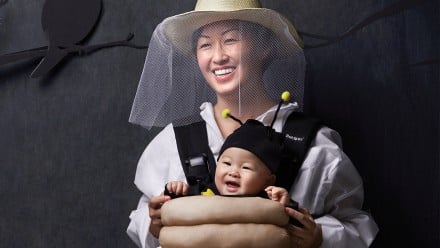 Mother and baby dressed as a beekeeper and bee in a hive