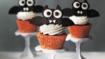 Cupcakes with bats on top of them made of Oreos