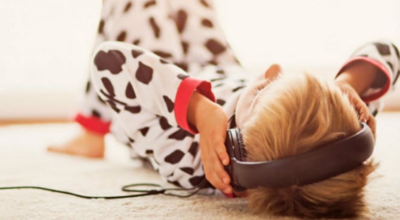 kid laying on the floor listening to music