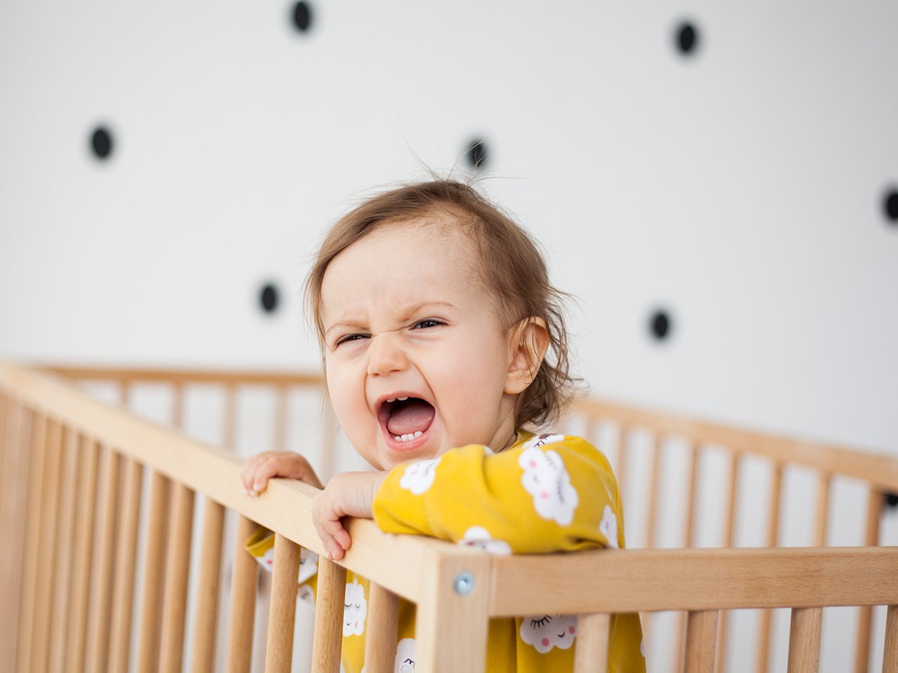 A little girl screaming in her crib