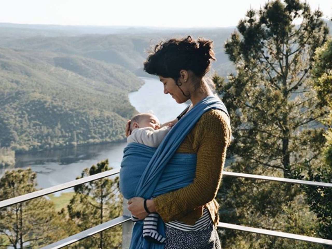 woman breastfeeding baby by mountain