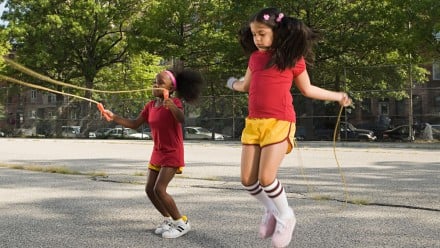 two girls skipping rope in a school yard