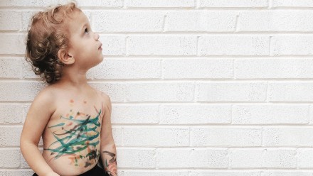 A little boy who has coloured in marker all over himself