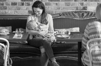 Woman sitting in a cafe breastfeeding