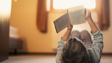 a little boy binge readings a novel in the summertime