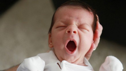A baby yawning really big
