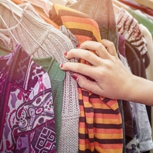 Photo of a hand on a rack of clothes