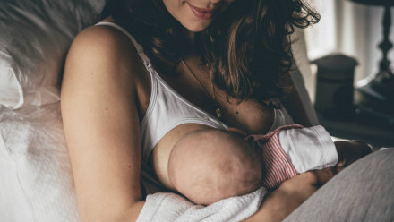Mom feeding baby learning how to treat sore nipples