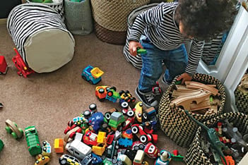 toddler surrounded by toy cars