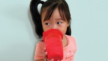Little girl using a sippy cup