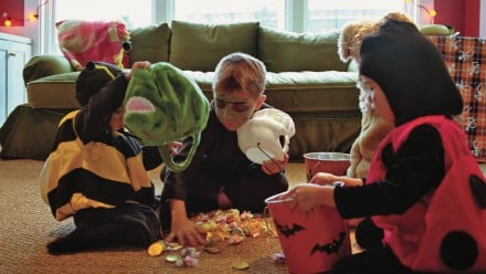 A bunch of kids in costumes divvying up their candy