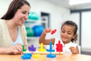 Woman playing blocks with child