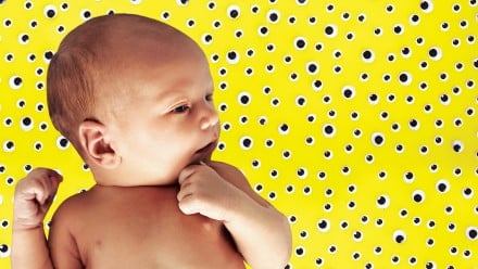 Baby laying on yellow background with googly eyes all around representing bacteria
