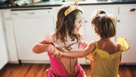 A little boy and girl dancing in princess dresses