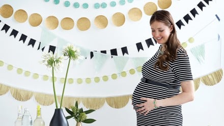pregnant woman at baby shower with table of food