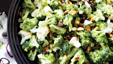 bowl of broccoli and cauliflower salad with seeds and dried berries