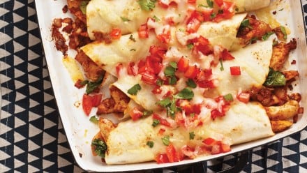 roasting pan with rolled up chicken enchiladas