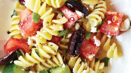 plate of pasta with olives, tomatoes and cucumber