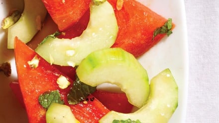 wedges of watermelon with cucumber and mint in a light oil-based dressing
