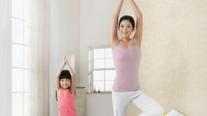 mom and daughter doing yoga pose