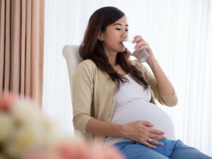 pregnant woman drinking supplement