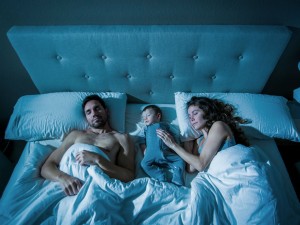 Parents with a sleeping toddler in their bed