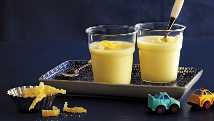 Two cups with lemon pudding and candied lemon peels on top
