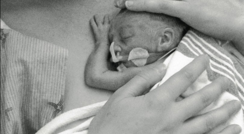 Close up of mom holding baby in the NICU providing skin to skin contact