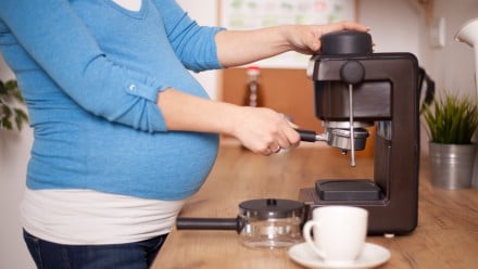 A pregnant woman pouring coffee