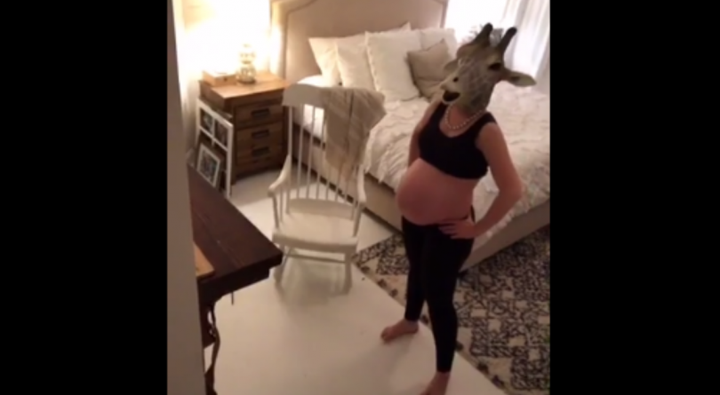 pregnant woman wearing a giraffe head