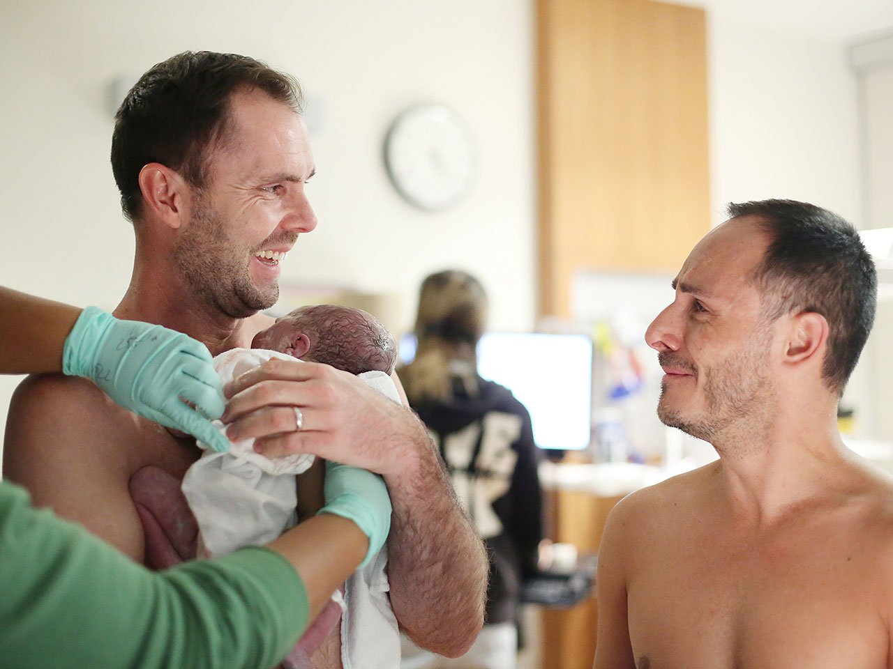 The author and his partner holding their new baby at the hospital